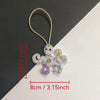 Handcrafted rhinestone bag charm featuring a purple and white sequin octopus and turtle pendant keychain.