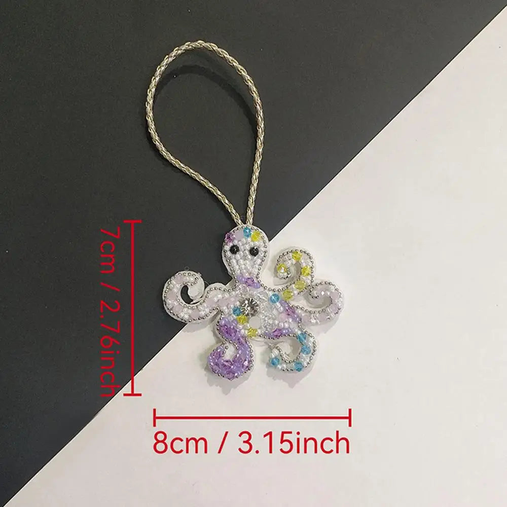 Handcrafted rhinestone bag charm featuring a purple and white sequin octopus and turtle pendant keychain.