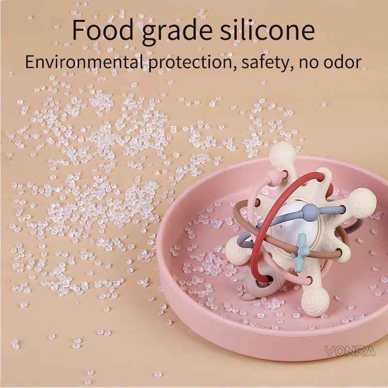 Pink silicone sensory rattle ball with attached rings for baby development