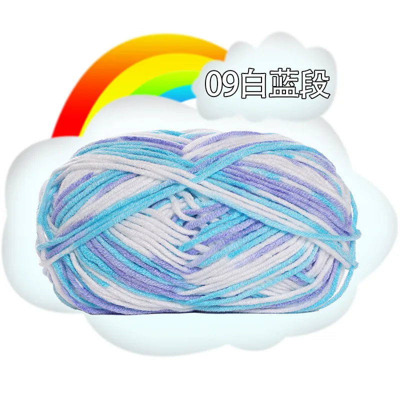 A ball of light purple and white milk cotton blend yarn is shown against a rainbow background.