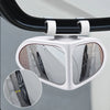 A white adjustable blind spot mirror for a car mounted on a rearview mirror.