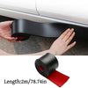 A hand is applying a black self-adhesive PVC strip to protect a car's door edge or side skirt.