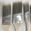 A set of three metal paint brushes with wooden handles and silver ferrules for painting projects.