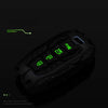 A black protective key fob cover with green LED indicators is shown against a dark background.