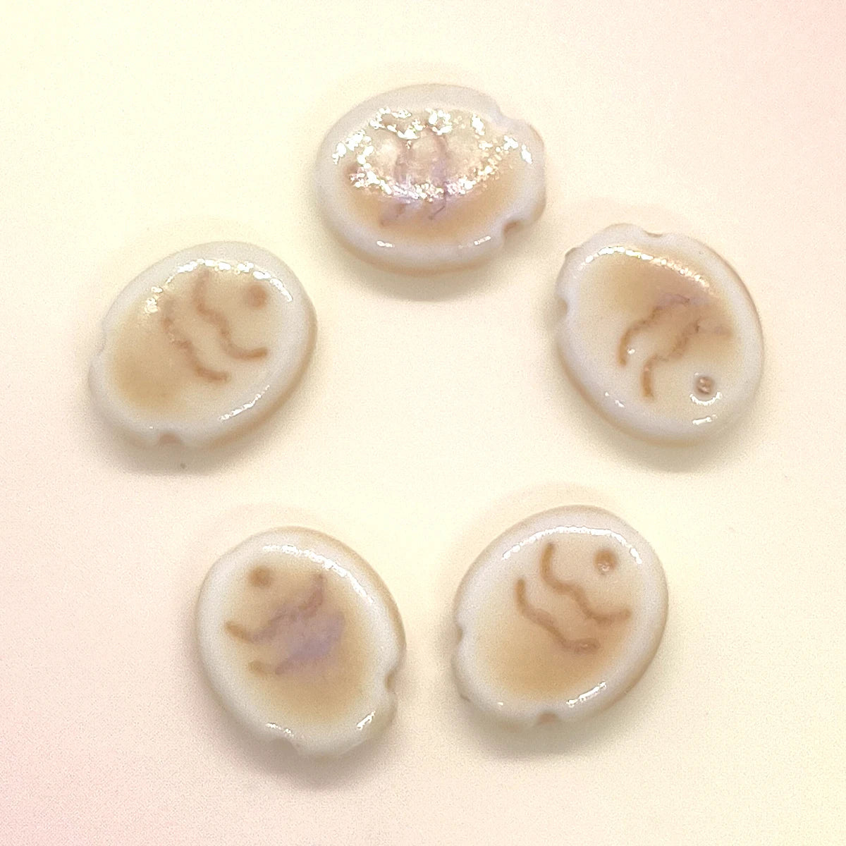 Five handcrafted ceramic fish beads showing natural variations in color and pattern