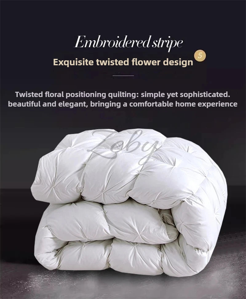 A stack of white goose down quilts featuring an embroidered stripe and twisted flower design.