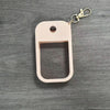 A light pink silicone protective case for a hand sanitizer spray attached to a metal keyring.