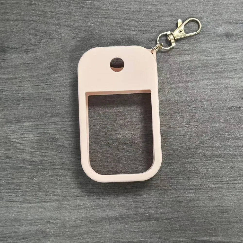 A light pink silicone protective case for a hand sanitizer spray attached to a metal keyring.