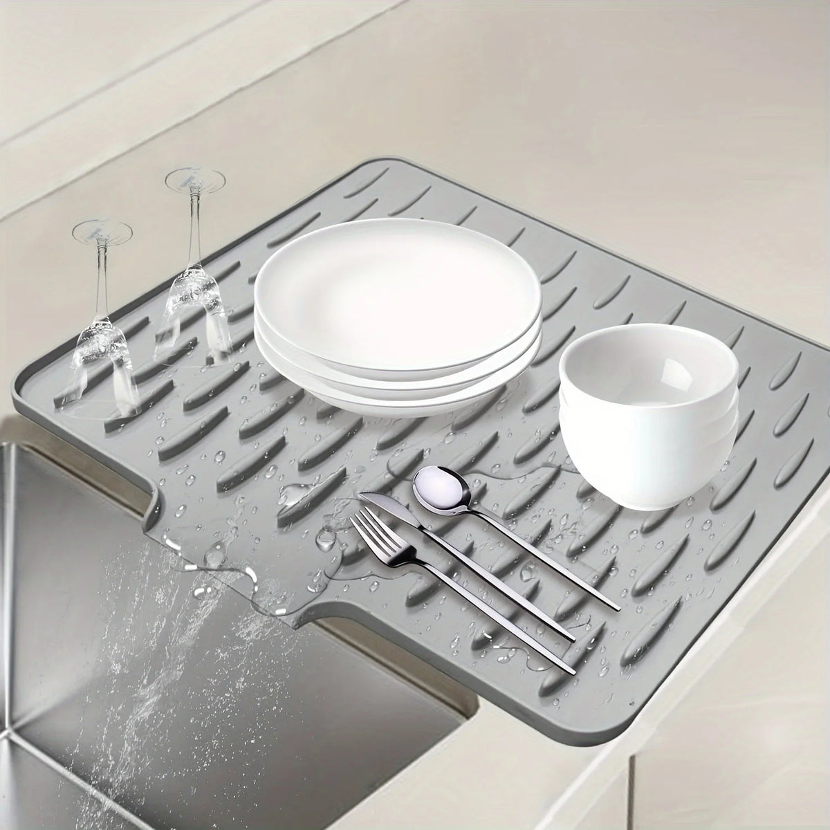 A silicone dish drying mat is shown holding a stack of white plates and a bowl, with water dripping off the items.