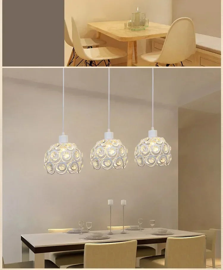 Three crystal single-head ceiling lamps hanging above a modern dining table.