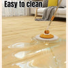 A mop is cleaning a wooden floor, showing water streaks and a glossy finish on the wood grain.
