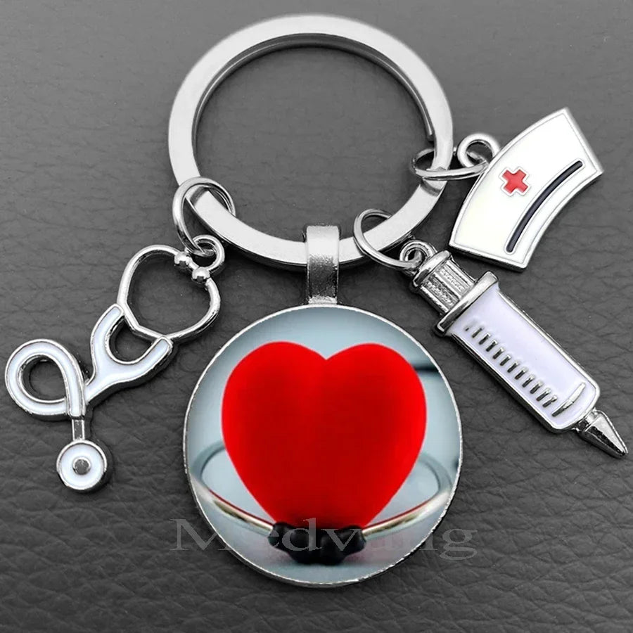 Silver nurse keychain featuring a heart-shaped glass dome and a medical syringe charm