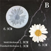 A white silicone mold shaped like a daisy flower is shown on a dark marble surface.