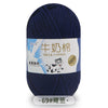 A skein of dark blue milk cotton blend yarn with a label indicating the product name and stretch features.
