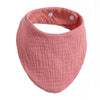 A pink organic cotton muslin baby bib with a textured, absorbent band.
