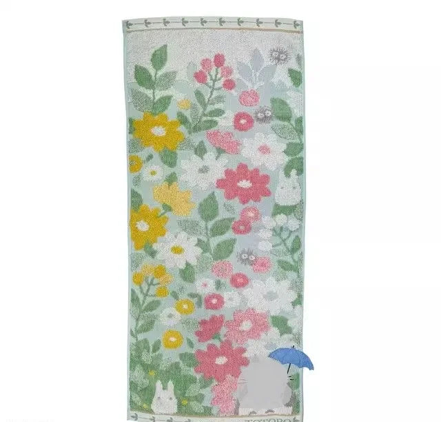 A rectangular face towel featuring a delicate floral embroidery design in shades of green, pink, and yellow.
