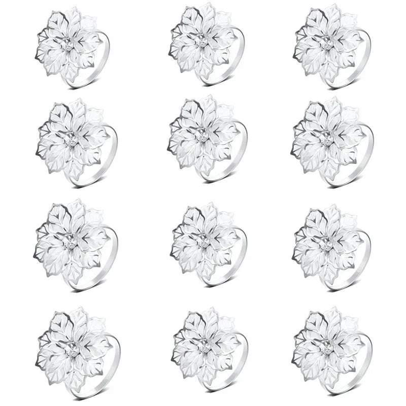 A set of twelve decorative metal napkin rings featuring a hollow-out floral pattern.