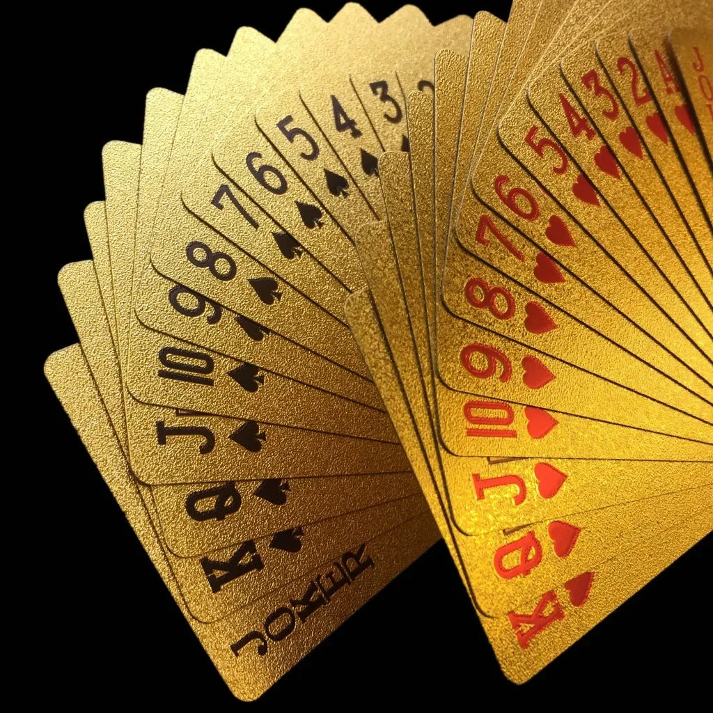 A fan of shiny 24K gold waterproof playing cards arranged in a stack.