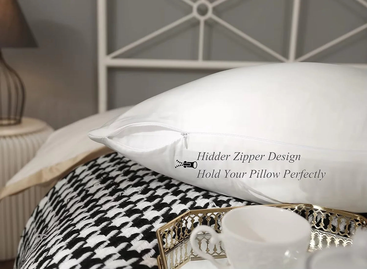 Un oreiller blanc avec un motif de fermeture éclair posé sur un tissu à motifs noir et blanc.