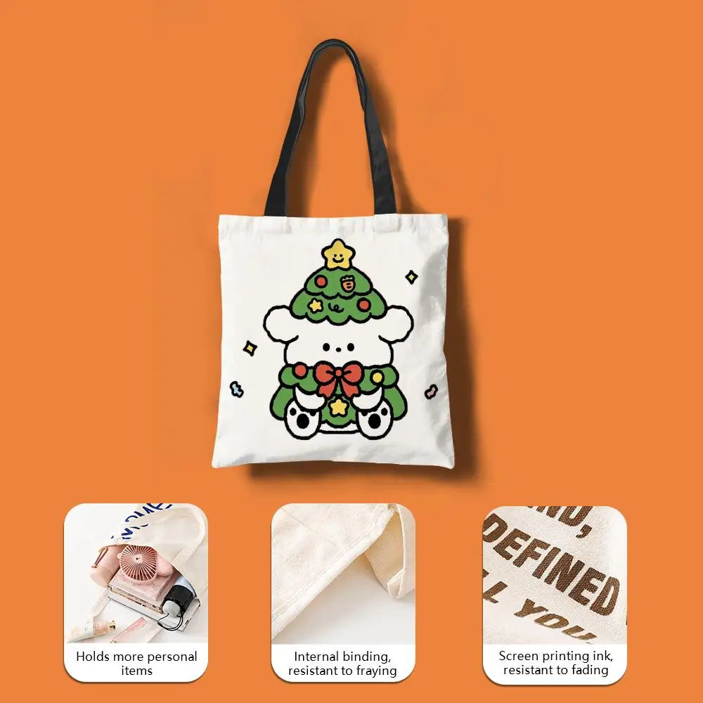 White canvas tote bag featuring a green Christmas tree design with a bow and festive elements.