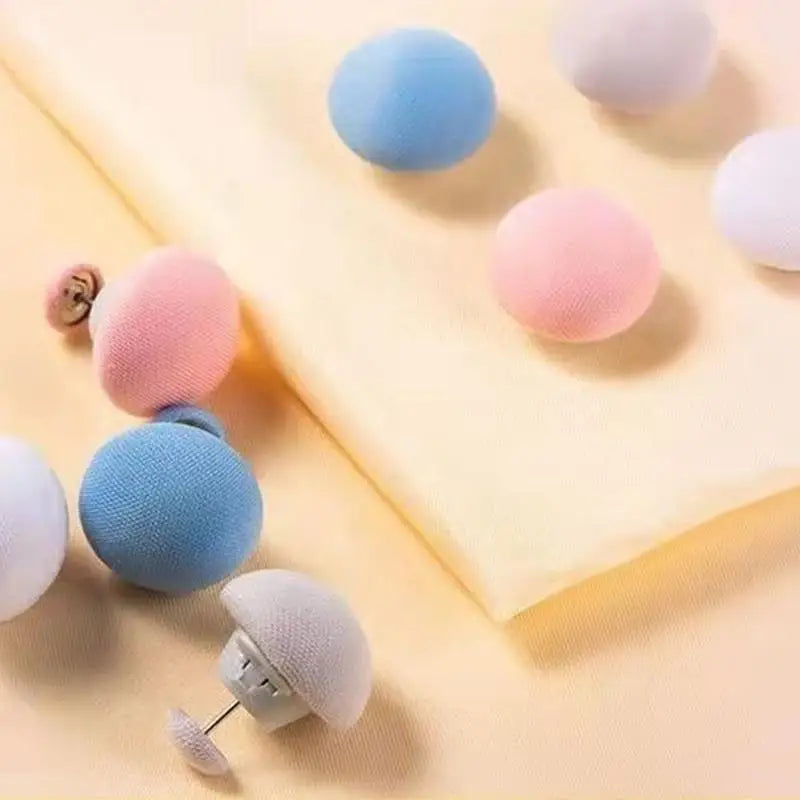 A set of six colorful, round non-slip clips in shades of blue, pink, and purple are displayed on a yellow fabric.
