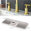 A silicone faucet splash mat with a ribbed design is shown next to brass faucet handles.