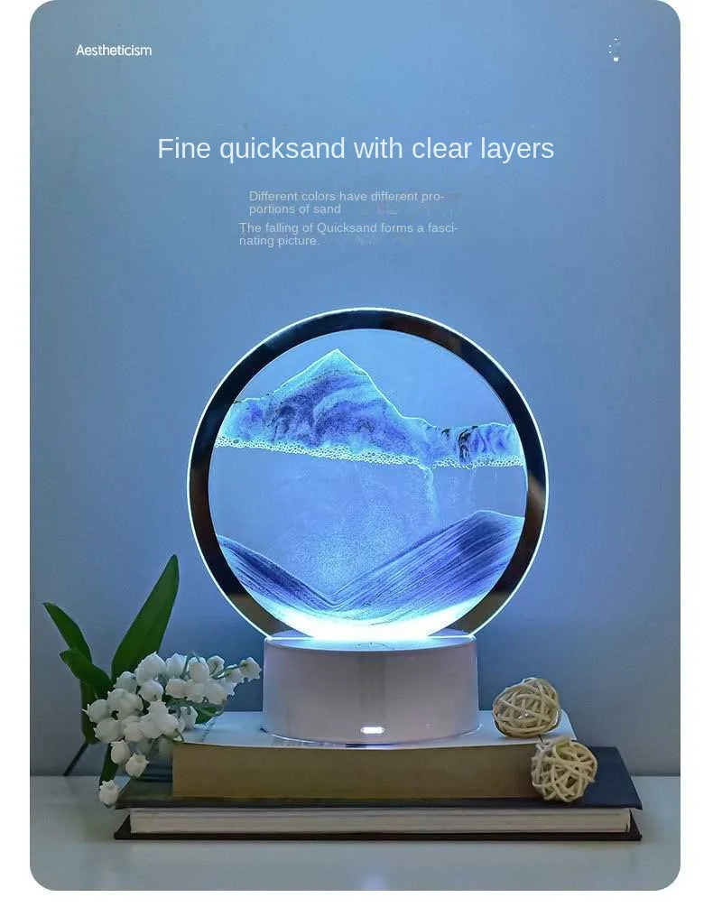 A glass hourglass filled with sand creating a layered landscape under a blue night light.