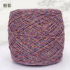 A ball of metallic silk crochet yarn with a shimmering purple and gold thread for knitting and macrame.