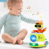 A baby is interacting with an orange toy car that plays music and lights, set against a white background.