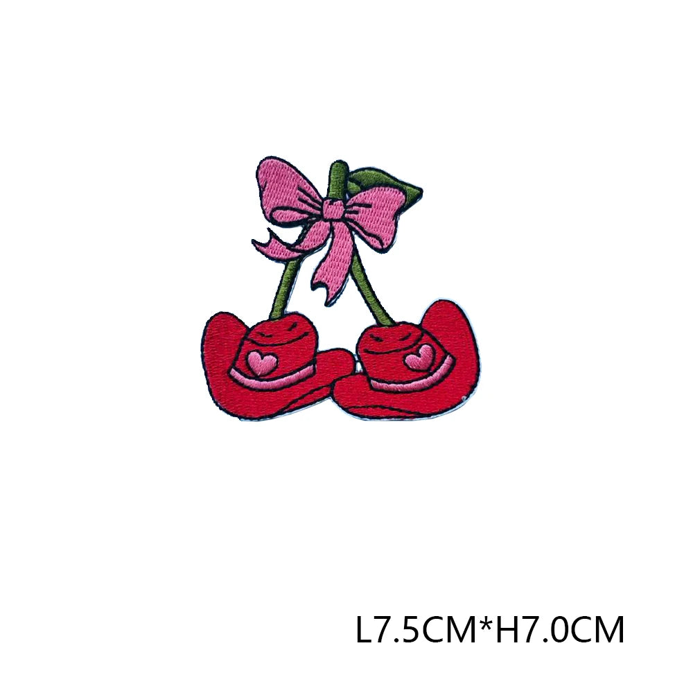 Pink and red embroidered letter patches featuring a bow and two hearts on green stems