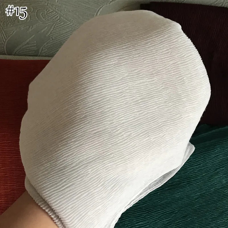 لقطة مقربة لوشاح أو شال قطني ناعم ومجعد أبيض يتم حمله من قبل شخص.