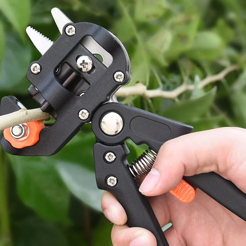 A hand holds a black precision grafting pruner with three interchangeable blades, used for fruit trees and vines.