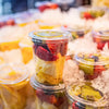 Clear plastic cups filled with colorful fruit and ice for cold drinks