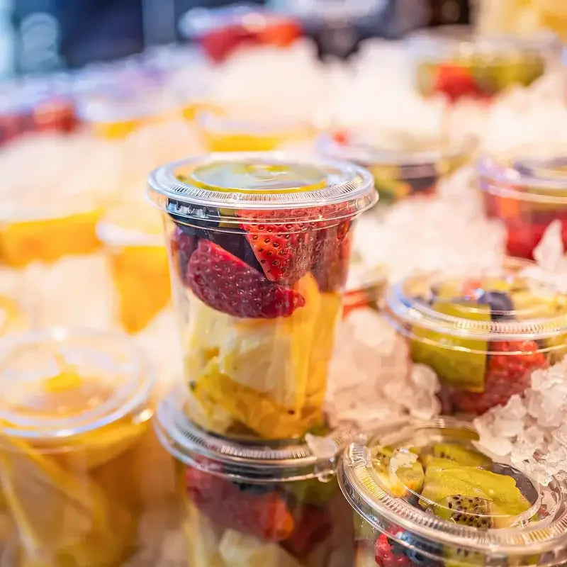 Clear plastic cups filled with colorful fruit and ice for cold drinks