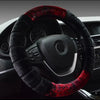 A black steering wheel covered with a red and black fuzzy plush material in a car interior.