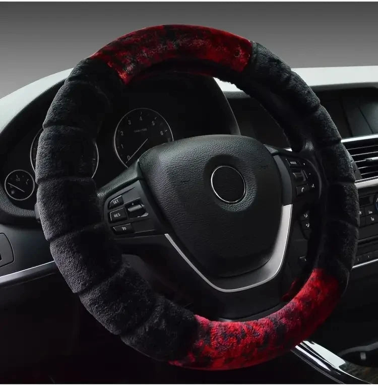 A black steering wheel covered with a red and black fuzzy plush material in a car interior.