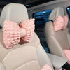 Pink bowknot car neck pillow with lumbar support placed on a light-colored car seat.
