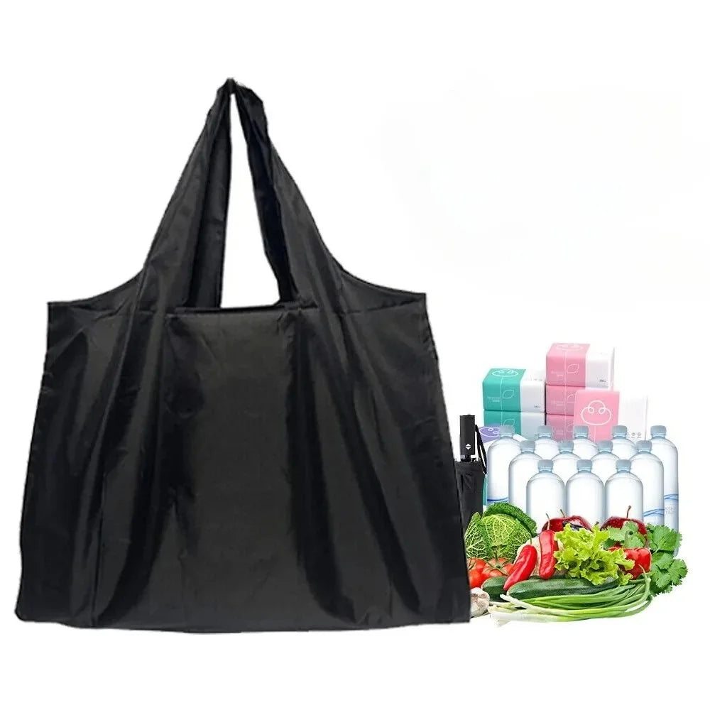 Black foldable nylon shopping tote bag next to various green and red vegetables and bottles