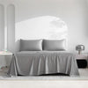 Luxuriöses Bambusbettlaken-Set in Grau über einem Bett in einem hellen, minimalistischen Raum.