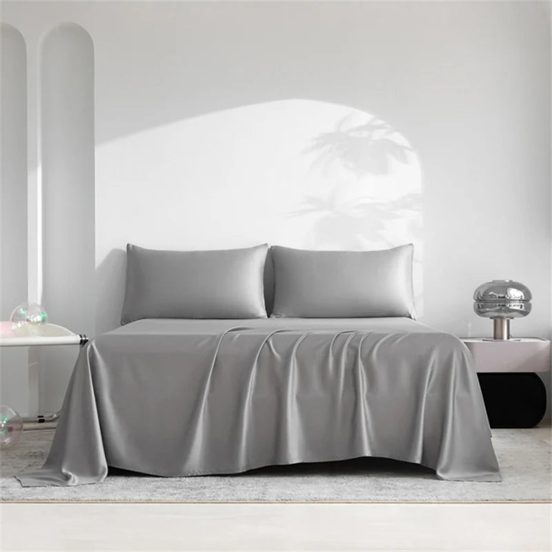 Luxuriöses Bambusbettlaken-Set in Grau über einem Bett in einem hellen, minimalistischen Raum.