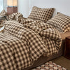 A plaid duvet cover in brown and beige tones with a checkered pattern on a bed.