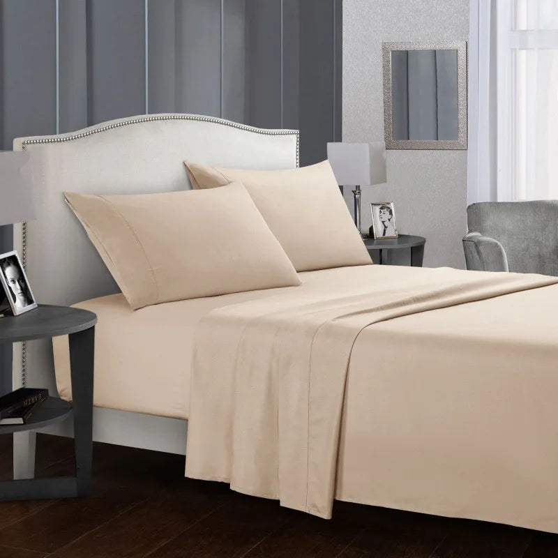Un lit beige avec tête de lit blanche et literie en lin dans une chambre moderne.