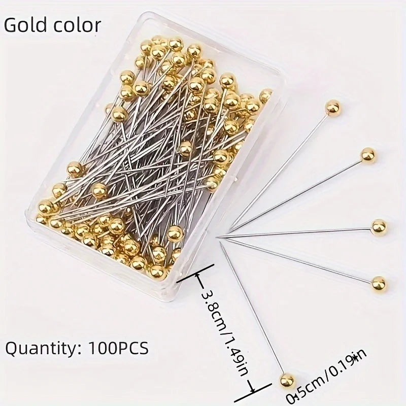 A clear plastic container holds 100 gold color precision quilting pins with silver wire and gold tips.