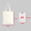 A white canvas shopping tote bag with handles shown next to an A4 sized piece of paper for scale.