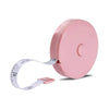 A pink flexible soft tape measure with dual-sided markings is shown against a white background.