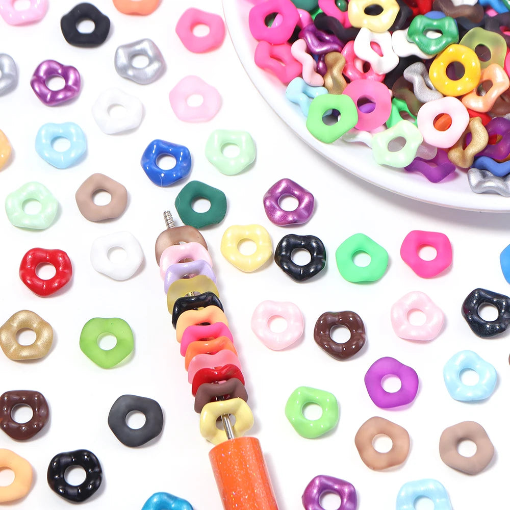 A collection of colorful acrylic spacer beads in various shapes and colors for jewelry making.