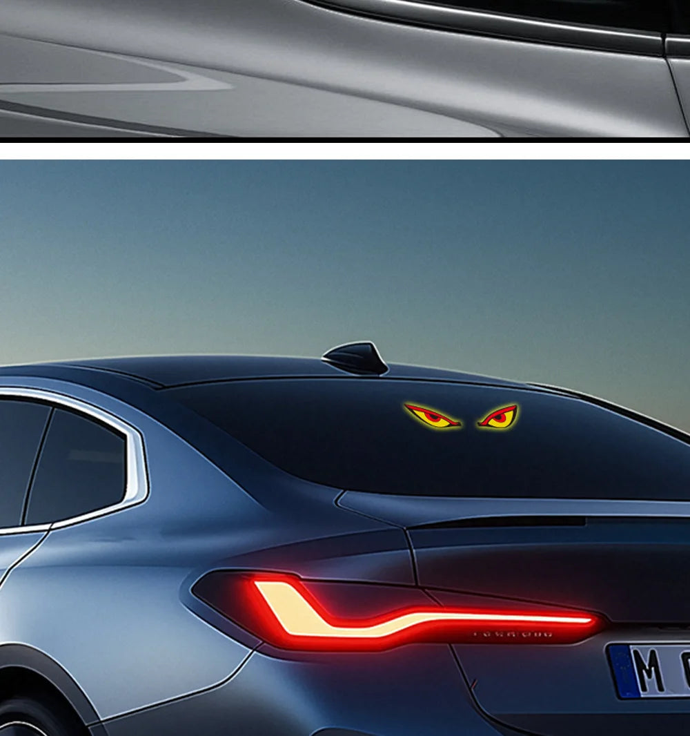 Close-up of a dark blue car with a red LED demon eye decal on the hood and a similar light strip on the front fender.