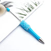 A close-up of a sparkling blue ballpoint pen with a sequin tip resting on white paper.