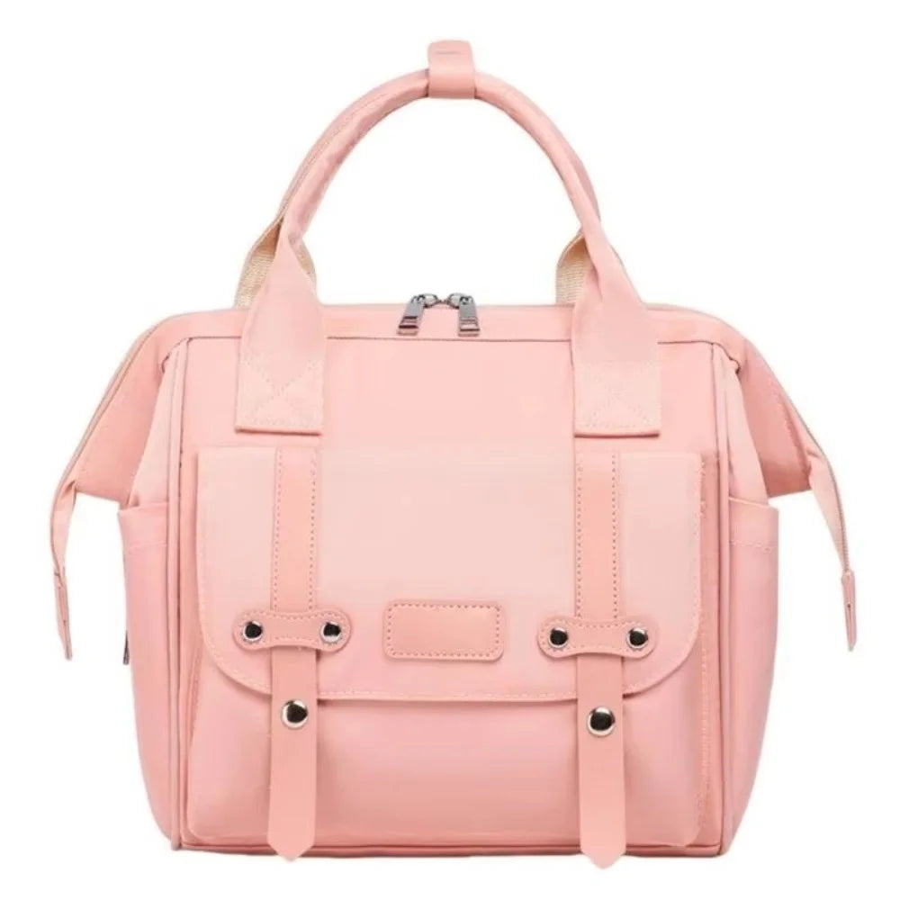 A pink compact diaper backpack featuring a padded compartment and bottle holder.