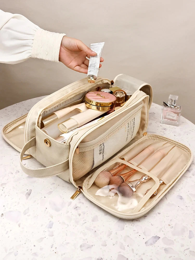 A beige cosmetic bag is shown open, revealing various makeup and grooming tools, with a hand holding a cosmetic product above